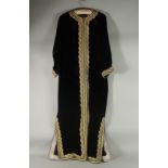 AN ARAB BLACK VELVET HOUSE COAT / ROBE, with gold thread decoration.