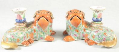 A FINE PAIR OF CHINESE CANTON FAMILLE ROSE PORCELAIN FOO DOG CANDLESTICKS, painted with floral
