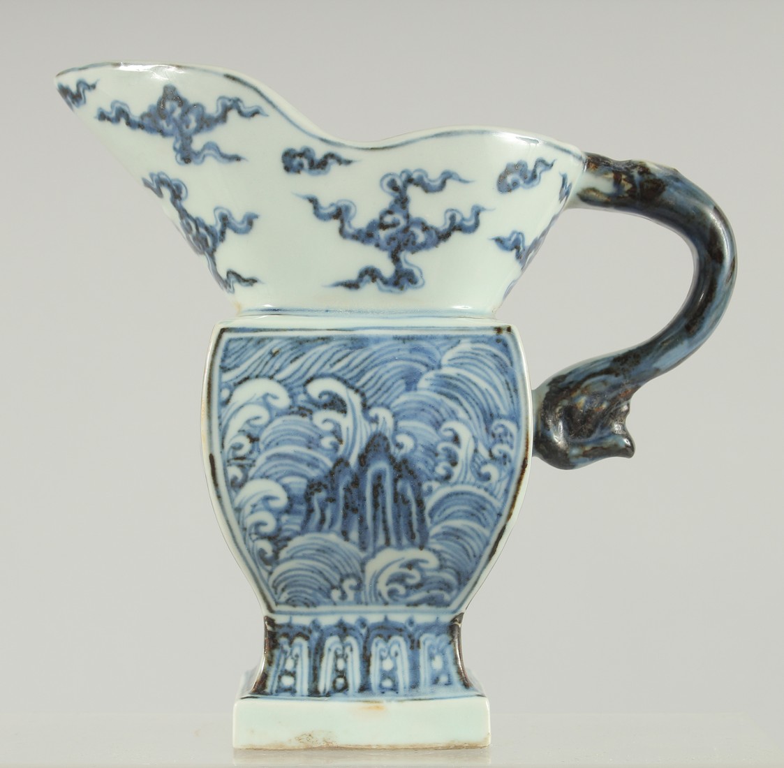 A CHINESE BLUE AND WHITE PORCELAIN JUG, with panels of stylised waves, 16.5cm high.