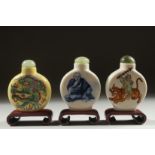 THREE CHINESE SNUFF BOTTLES AND STOPPERS with wooden stands, (3).