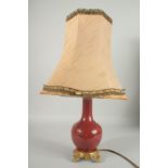 AN 18TH CENTURY CHINESE COPPER RED PORCELAIN VASE, converted to a lamp with ormolu mounts, shade