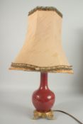 AN 18TH CENTURY CHINESE COPPER RED PORCELAIN VASE, converted to a lamp with ormolu mounts, shade