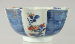 A 19TH CENTURY JAPANESE BLUE AND WHITE IMARI PORCELAIN BOWL, decorated with panels of flora,