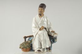 A CHINESE SHIWAN GLAZED POTTERY SEATED FIGURE, 23cm high.