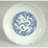 A CHINESE BLUE AND WHITE PORCELAIN DISH, with incised white dragon on stylised waves, six-