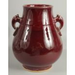 A CHINESE OX BLOOD GLAZE TWIN HANDLE VASE, 26cm high.