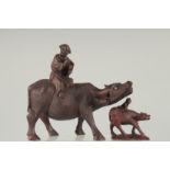 A CHINESE CARVED WOOD FIGURE OF A MAN UPON AN OXEN, together with a smaller similar figure, (2).