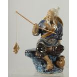 A CHINESE SHIWAN GLAZED POTTERY FIGURE OF A FISHERMAN, 19cm high.