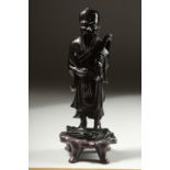 A CHINESE BAKELITE FIGURE on a fitted wooden stand, figure 15cm high.