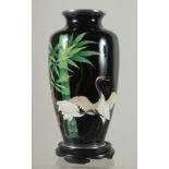 A JAPANESE BLACK GROUND CLOISONNE VASE, with cranes and bamboo, the foot rim marked 'Japan', '