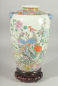A CHINESE FAMILLE ROSE PORCELAIN VASE on hardwood stand, painted with exotic birds and native flora,