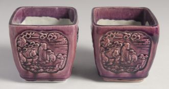 A PAIR OF EARLY 20TH CENTURY CHINESE PURPLE GLAZE FLOWER POTS, with panels of relief decoration