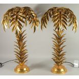 A PAIR OF GILT METAL PALM TREE LAMPS on circular bases. 25ins high.