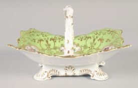 A 19TH CENTURY ROCKINGHAM OVER-HANDLED BASKET painted with five panels of flowers on a light green
