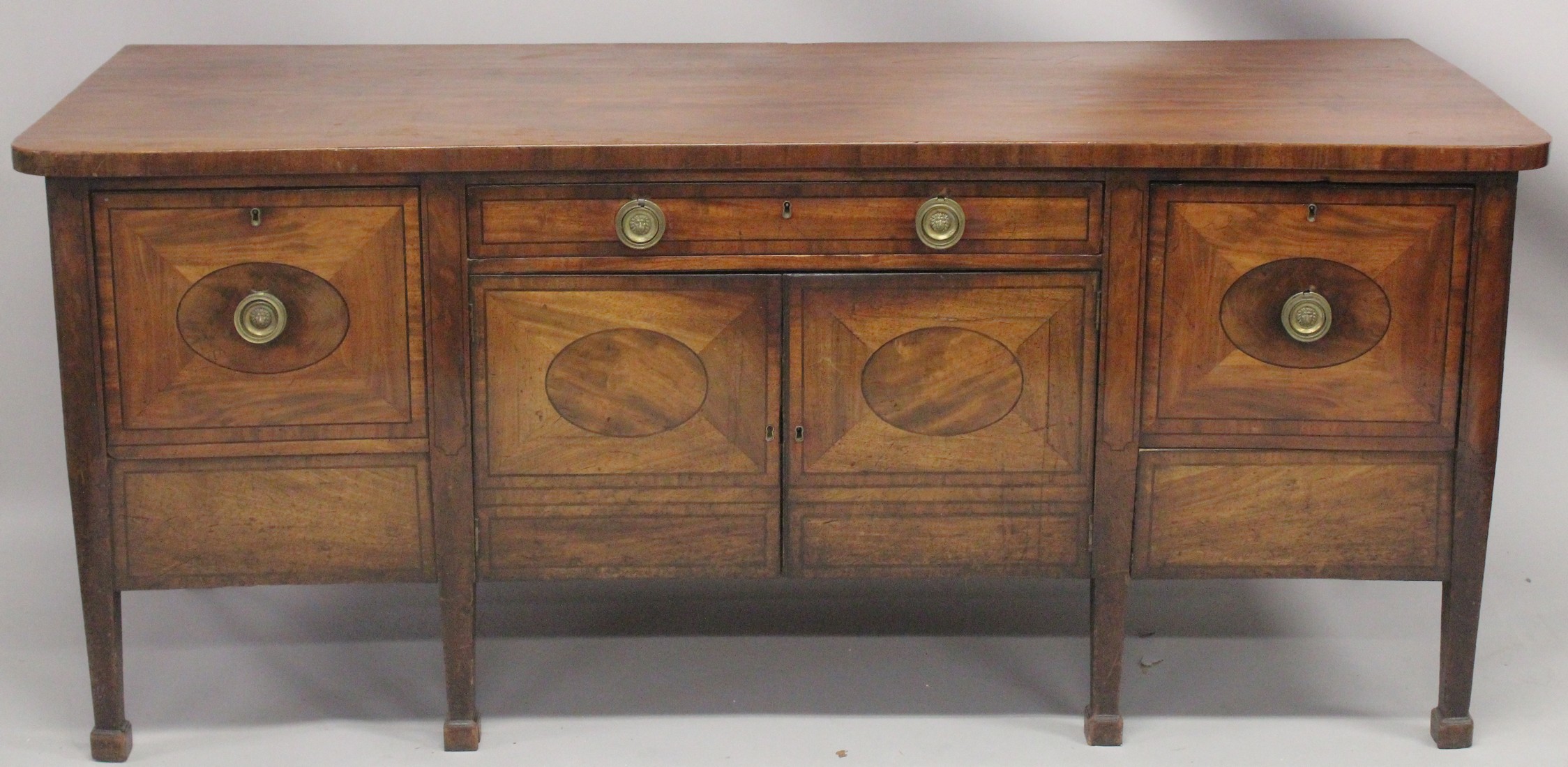 A GOOD GEORGE III MAHOGANY STRAIGHT FRONTED SIDEBOARD with plain legs and ovals to the front, with