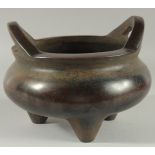 A GOOD LARGE CHINESE BRONZE CIRCULAR TWO HANDLED CENSER on three legs, Square mark. 10ins diameter.