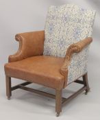 A GEORGE III MAHOGNAY GAINSBOROUGH ARMCHAIR with brass studs on straight legs with brass casters.