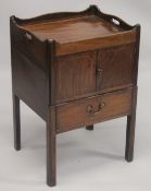 A GEORGE III MAHOGANY TRAY TOP BEDSIDE TABLE with hand apertures, the front with double panel