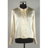 A CHANEL CREAM SILK BLOUSE with pearl style double C buttons and bow. Size 40