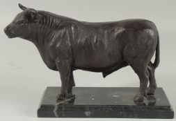 A BRONZE BULL on a marble base. 9ins long.