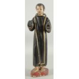 AN 18TH CENTURY CONTINENTAL CARVED WOOD AND PAINTED STANDING MONK with gilded robe.