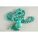 A LONG TURQUOISE BEAD NECKLACE AND PENDANT.