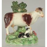 A STAFFORDSHIRE BOCAGE GROUP OF A COW AND CALF 5.5ins high.