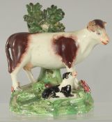 A STAFFORDSHIRE BOCAGE GROUP OF A COW AND CALF 5.5ins high.