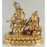 A GOOD GILT BRONZE GROUP OF TWO FIGURES set with stones, on an oval base. 11ins high, 10ins wide.
