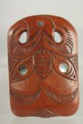 A MAORI CARVED WOOD MASK with mother of pearl eyes. 8.25ins x 6.5ins.