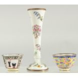 A SMALL ENAMEL SPECIMEN VASE painted with flowers. 5.25ins high and two enamel cups.