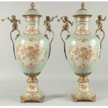 A PAIR OF SEVRES DESIGN PORCELAIN URN SHAPED VASES painted with flowers and gilt cupids. 20ins