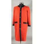 A CHANEL ORANGE DRESS COAT with navy trim and gilt Chanel double C buttons, silk lining. Size 38.