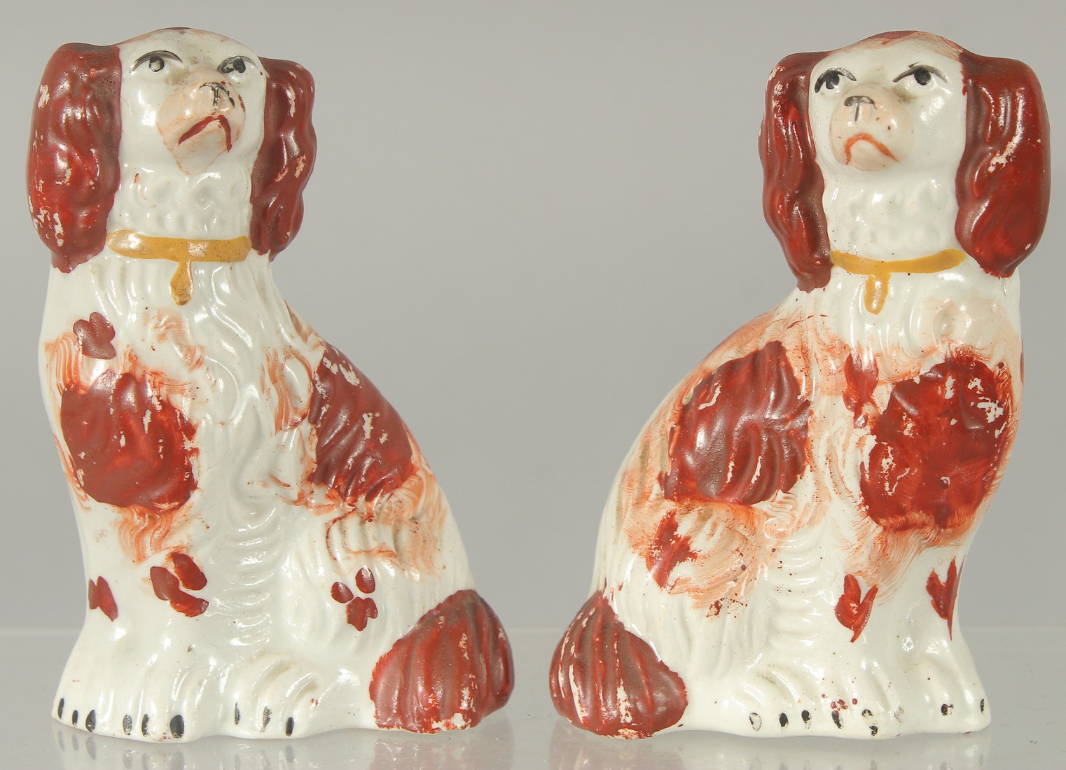 A SMALL PAIR OF STAFFORDSHIRE KING CHARLES SPANIELS 3.75ins high.