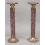 A PAIR OF RED MARBLE COLUMNS. 3ft 4ins high.