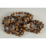 A STRING OF TIGER'S EYE BEADS. 38ins long.