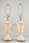 A PAIR OF GREEN PORCELAIN TWO HANDLED URN SHAPED VASE LAMPS. 15ins high.