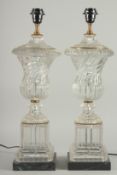 A GOOD PAIR OF GLASS URN SHAPED VASE LAMPS on square bases.