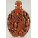 A CHINESE CARVED AMBER SNUFF BOTTLE AND SPOON.