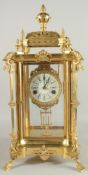 A GOOD GILT BRONZE FOUR GLASS CLOCK with pineapple finials on claw feet. 24ins high.