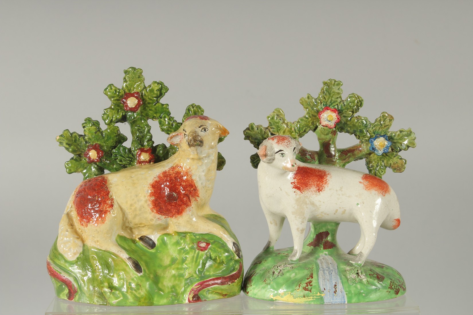 TWO STAFFORDSHIRE BOCAGE GROUPS OF A SHEEP with Bocage backs. 5.5ins & 4.5ins high.