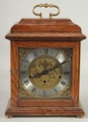 FRANZ HERMLE AN OAK CASED BRACKET CLOCK with Westminster chime, brass dial, silvered chapter ring