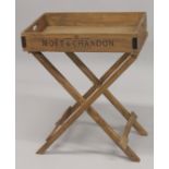 A MOET & CHANDON WOODEN BUTLERS TRAY on a stand.