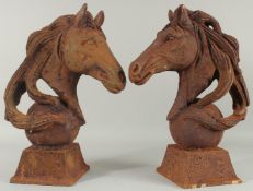 A PAIR OF CAST IRON HORSE'S HEADS on square bases. 18ins high.