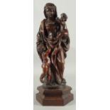 AN 18TH CENTURY CONTINENTAL CARVED WOOD MADONNA AND CHILD with a cupid, on a rectangular base. 1ft