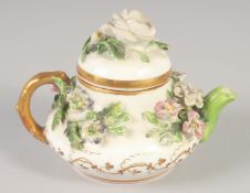 A 19TH CENTRUY ROCKINGHAM MINIATURE TEA POT AND COVER encrusted with flowers, printed griffin mark.