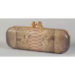 AN ALEXANDER MCQUEEN SNAKE SKIN BAG with two gilt scull handles. 9ins long, 3.25ins wide. 170