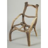 AN UNUSUAL MINIATURE DEER ANTLER ARMCHAIR. 1ft 4ins high x 1ft wide.