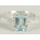 AN 18 CARAT WHITE GOLD HALLMARKED OCTAGONAL AQUAMARINE AND DIAMOND RING.