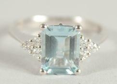 AN 18 CARAT WHITE GOLD HALLMARKED OCTAGONAL AQUAMARINE AND DIAMOND RING.